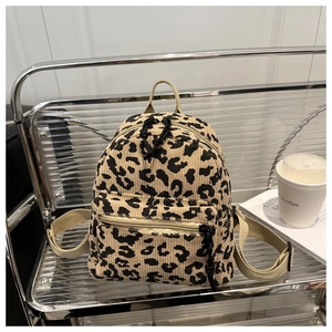 Macro view of leopard print corduroy mini backpack on a shelf showing texture and zipper