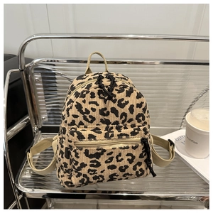 Detailed close-up of leopard print corduroy mini backpack with adjustable beige straps