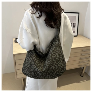 Detailed back view of a large leopard print canvas tote bag on a model's shoulder