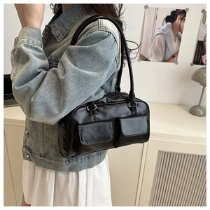 Detail of black faux leather tote bag with dual front flap pockets and long handles