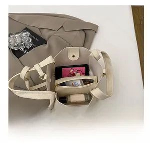 Interior view showing the large capacity of the cream leather bucket bag with daily items