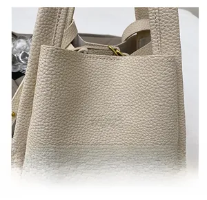 Macro detail of creamy litchi grain leather bag with embossed Fashion lettering