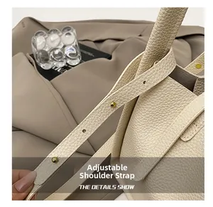Close-up of adjustable cream lychee grain leather strap with round gold metal studs
