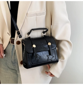 Détail du sac à main vintage noir avec broderie étoile et garnitures dorées élégantes