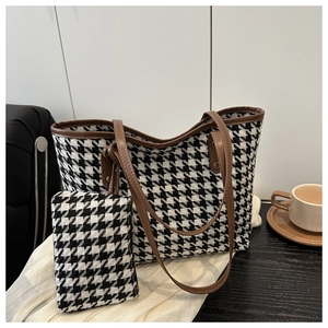 Detail of houndstooth tote bag with brown leather trim and matching small pouch