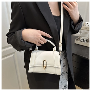 Detailansicht der weißen Lederhandtasche mit goldenem Metallverschluss und Trageriemen