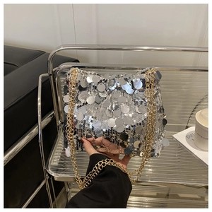 Close-up of silver sequin crossbody bag featuring gold chain straps and metallic texture