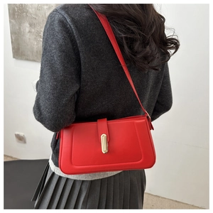 Rear view of model wearing a red leather shoulder bag with gold metal buckle detail