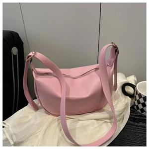 Detail view of pink PU leather half-moon bag with gold zipper and smooth texture