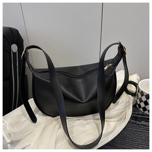 Detail of black crescent moon bag with wide adjustable shoulder strap and gold hardware