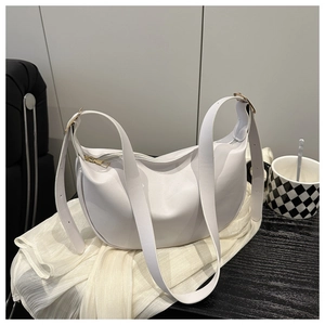 Detail shot of a white hobo bag with gold zipper and smooth faux leather texture