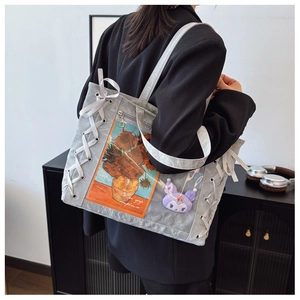 Detail view of large grey tote bag with transparent pocket and decorative white satin bows