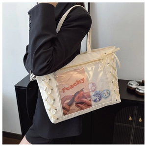 Detail view of cream canvas tote bag with transparent PVC window and ribbon weaving decoration