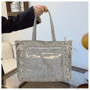 Detail of grey tote bag featuring glossy crinkled texture and transparent PVC front pocket