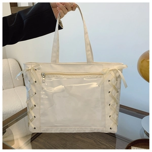 Detail of white tote bag with transparent PVC pocket and cute ribbon bow accents