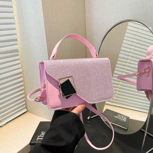 Pink crossbody bag with rhinestone flap and geometric buckle reflected in a mirror