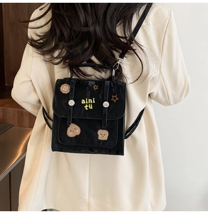 Detail eines schwarzen Mini-Rucksacks mit Stickereien und Metall-Magnetverschluss