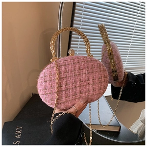 Detail of pink tweed evening clutch with golden ring handle and crystal push-lock clasp