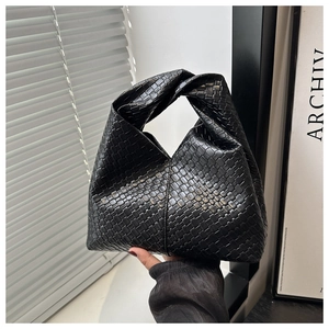 Close-up of black woven leather handbag with signature knot handle and Intrecciato pattern