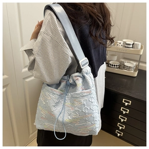 Dettaglio della borsa tote in nylon azzurro con ricami ondulati e tracolla larga regolabile