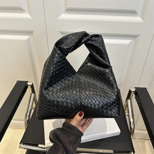 Black woven shoulder bag with knotted handle detail for a chic minimalist look