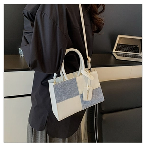 Detail of color-block square handbag featuring two-tone texture and Fashion Bag hangtag