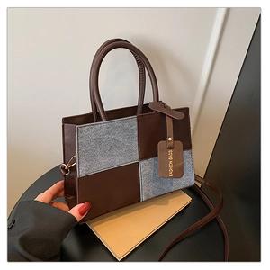 Detail of vintage brown leather and grey tweed patchwork handbag with fashion tag