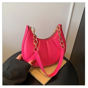 Macro shot of rose red pleated crescent shoulder bag with gold chain and PU texture