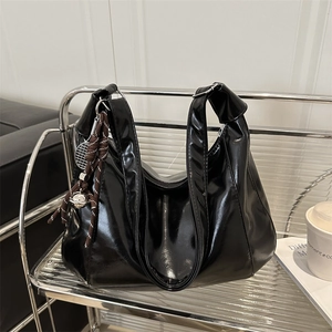Glossy black large capacity tote bag with woven charm and shoulder strap for daily commuting