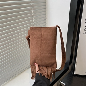 Sac bandoulière chic en daim caramel foncé avec pompons et style bohème moderne