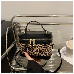 Détail du sac boîte léopard avec fermetures éclair dorées et poignées au style vintage