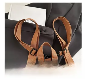 Detail of the leopard print backpack showing durable brown woven shoulder straps and buckle