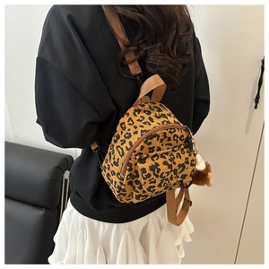 Detailed back view of a small leopard print corduroy backpack with adjustable brown straps
