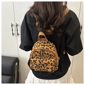 Detail view of leopard print corduroy mini backpack on person showing texture and size