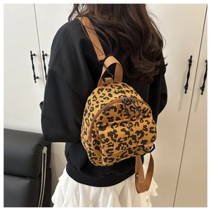 Detail view of mini backpack in yellow leopard print corduroy fabric with nylon straps