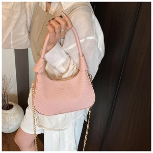 Close-up of pink crescent underarm bag with woven texture and gold chain on shoulder
