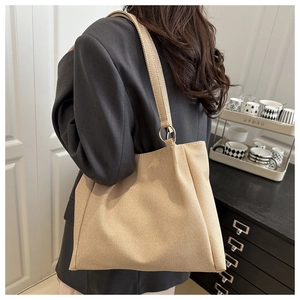 Détail d'un grand sac cabas en toile rayée beige avec des anneaux de connexion dorés élégants