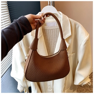 Detail of caramel brown woven leather hobo bag with gold chain strap and smooth zipper