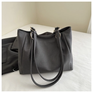 Detail of black twill fabric tote bag with long straps and gold metal ring connectors
