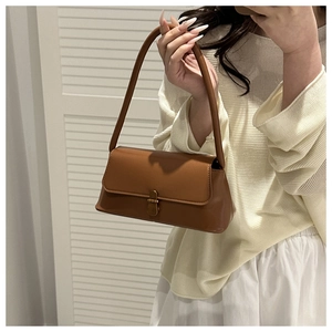 Detail of vintage brown shoulder bag with bronze metal clasp and matte leather texture