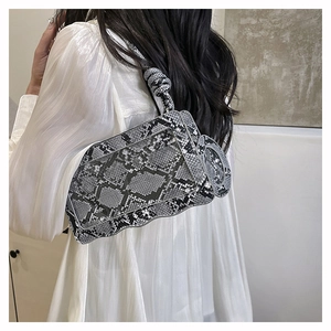 Detail of grey snakeskin pattern bag with wavy edge and knotted shoulder strap detail