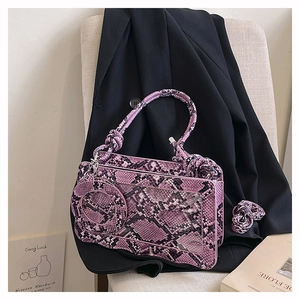 Detail of purple snakeskin bag featuring a woven rope handle and transparent window window