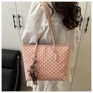 Detail view of pink tote bag with letter prints and brown plush rabbit charm
