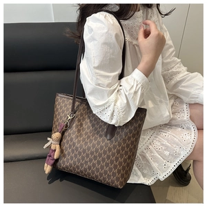 Brown tote bag with M-monogram print, leather handles, and a cute rabbit charm detail