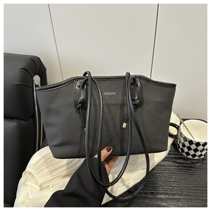 Close-up of black oil wax leather tote bag featuring silver Fashion lettering detail