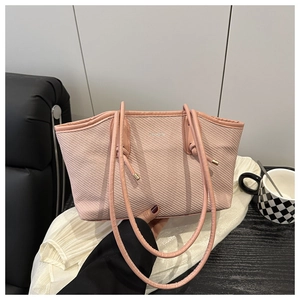 Detailed view of pink textured fabric shoulder bag with FASHION logo and knot handle