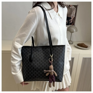 Detail of large monogram tote bag with textured M print and brown rabbit plush charm