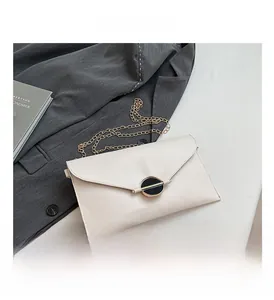 Détails de la pochette enveloppe blanche avec bandoulière chaîne et boucle dorée