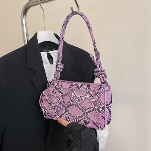Purple snake skin pattern underarm bag with decorative knotted handle and small round purse