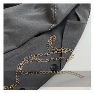 Détail de la chaîne dorée avec des surpiqûres blanches contrastées sur le tissu